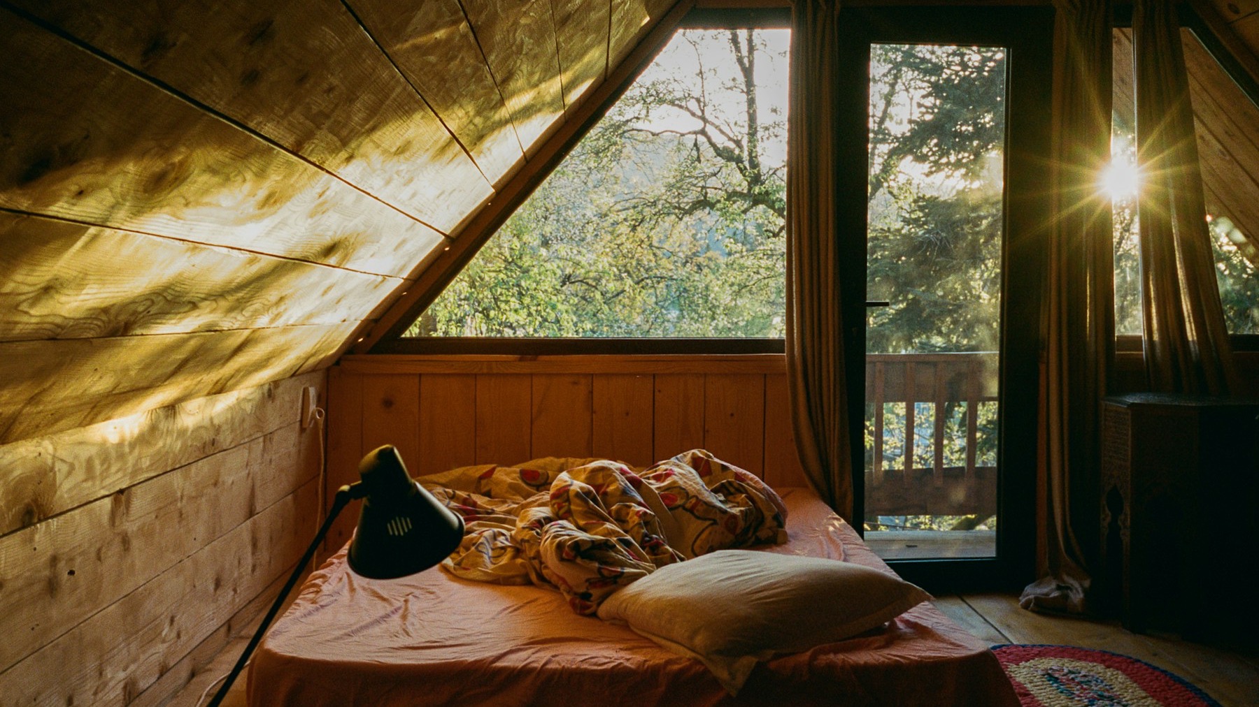 Sunlit bedroom with a window and an unmade bed