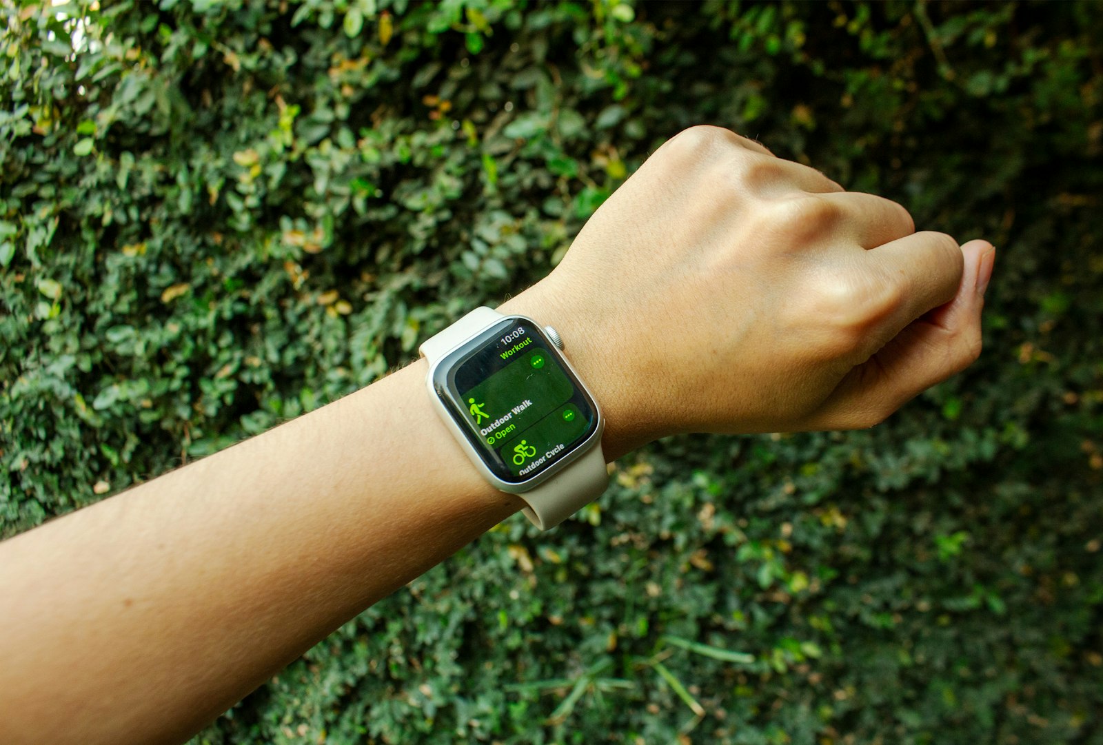 A hand with an Apple Watch on the wrist, ready to start an outdoor walk