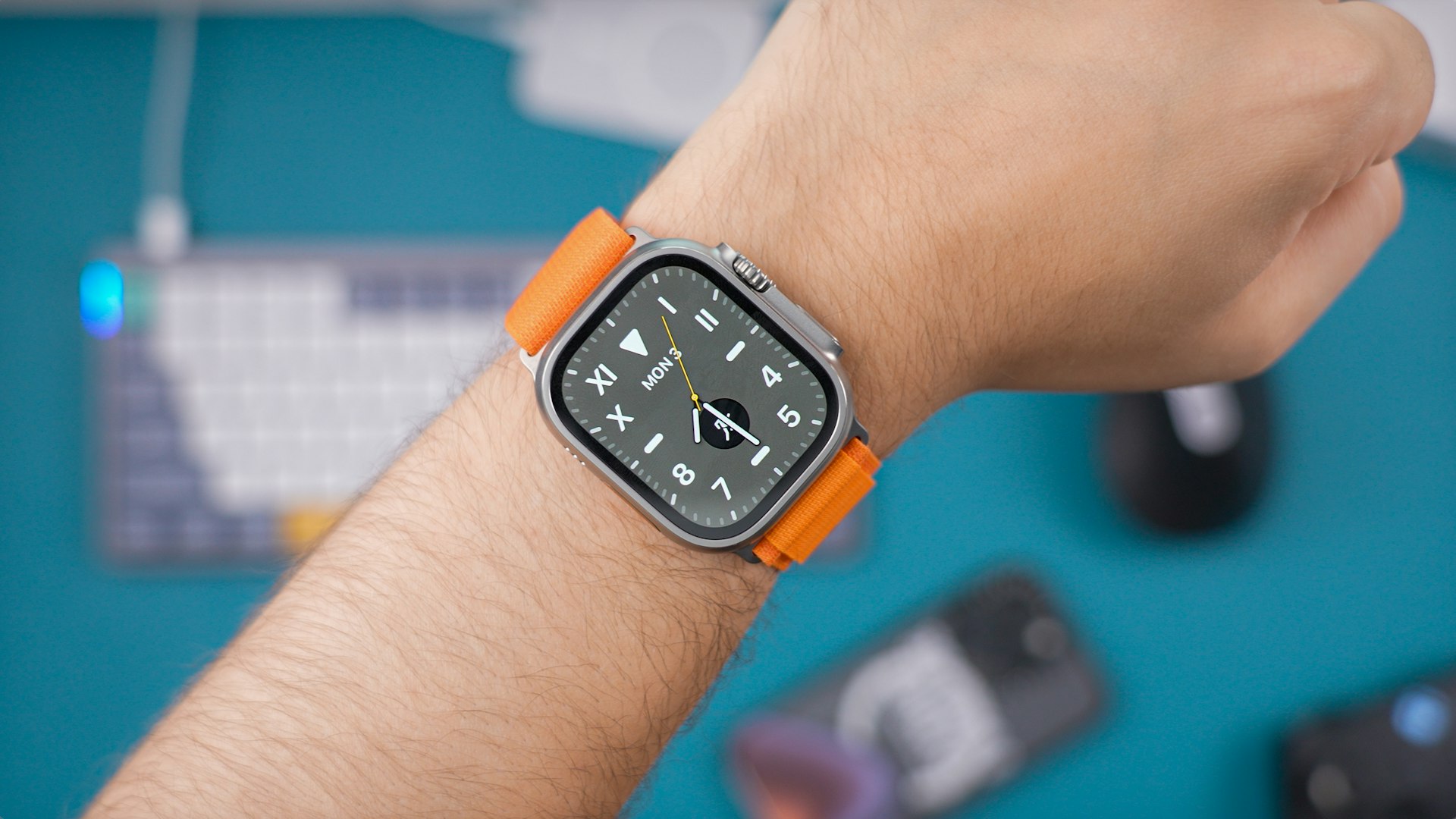 Apple Watch Ultra with an orange band on a wrist