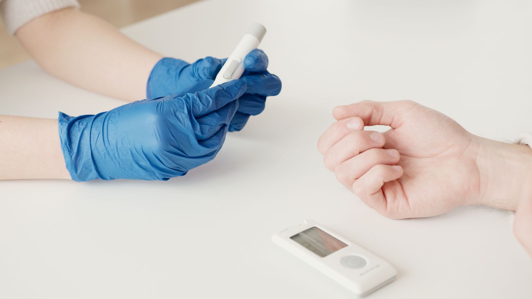 Healthcare worker checking blood sugar with a glucometer