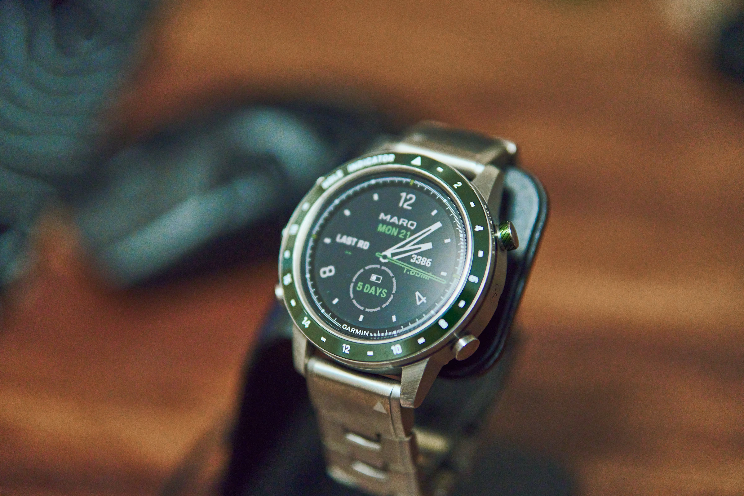 A smartwatch with a green bezel on display,