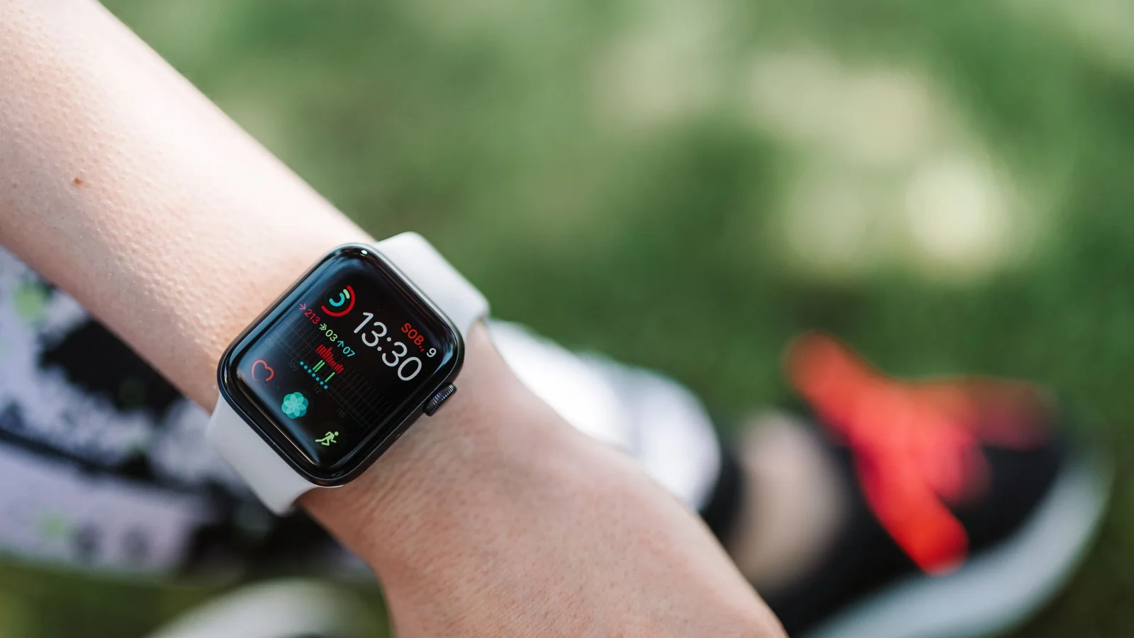 Apple Watch on a wrist displaying heart and fitness metrics outdoors