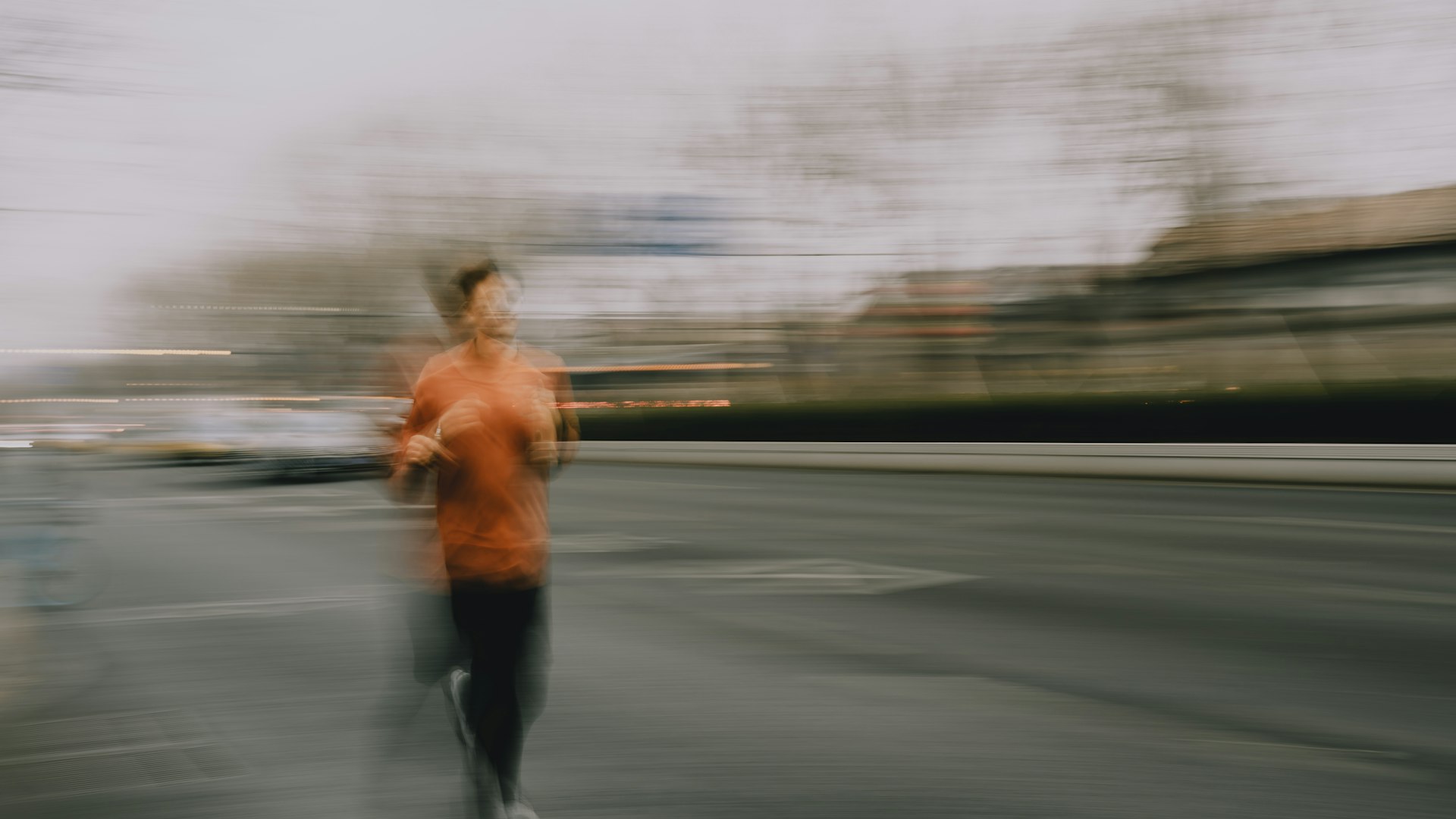 A runner blurred in motion on a city street