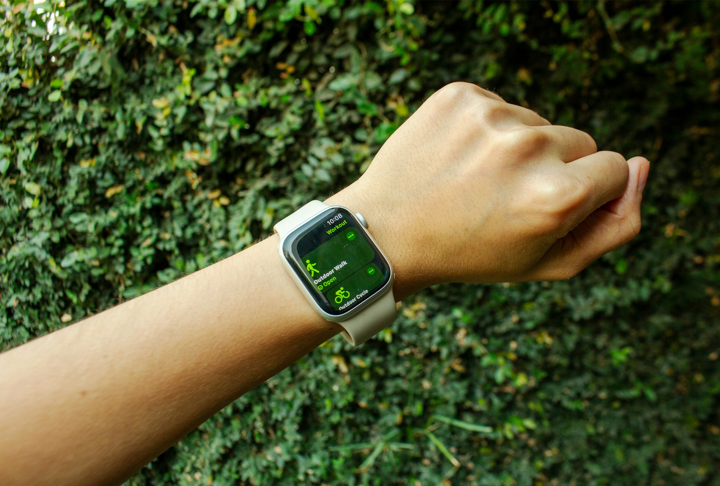 Apple Watch on a wrist against green ivy